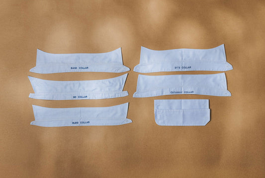 Selection of made to measure collar types laid out on brown background
