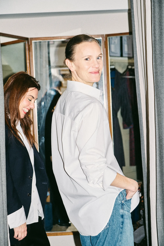 Author Jo Ellison wearing a white shirt in the changing rooms at Budd Shirtmakers
