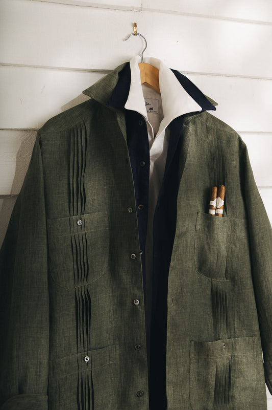 Khaki green Guayabera Shirt hung up against white boards