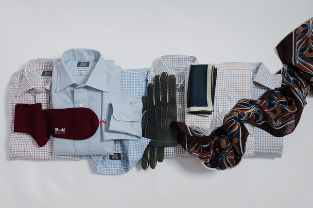 Array of brushed cotton shirts with autumn winter accessories laid flat on plain background