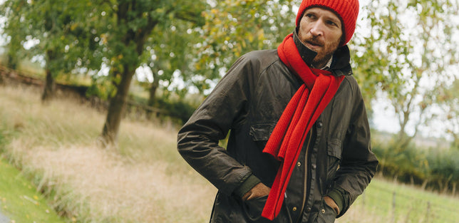 Man wearing knitted scarf and matching hat outdoors