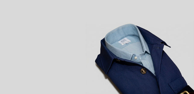 Navy blue overshirt with blue shirt inside, on pale grey background