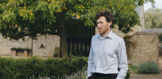 Model wearing a casual shirt in blue stood outside in garden