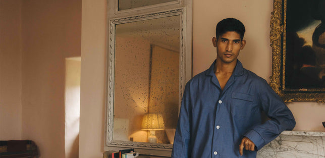 Male model wearing blue classic fit pyjamas in bedroom
