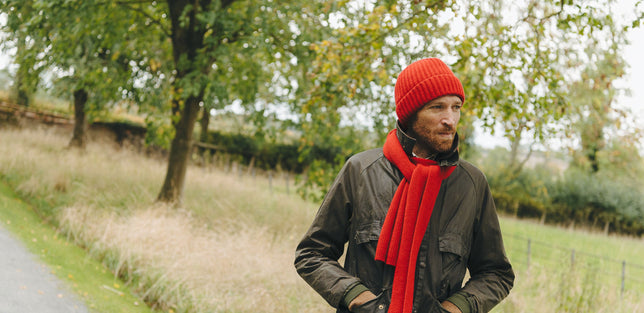 Man wearing red knitted hat and scarf outdoors