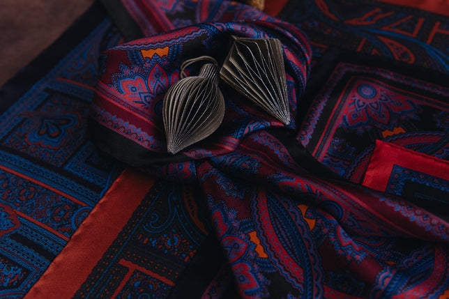 Madder silk pocket squares laid out with christmas bauble