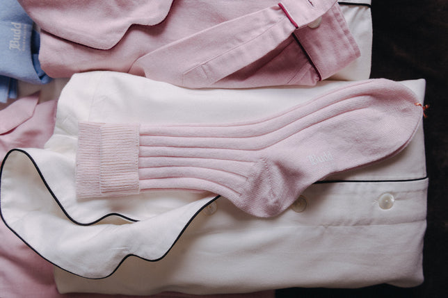 Womens Pink Socks laid on white pyjamas