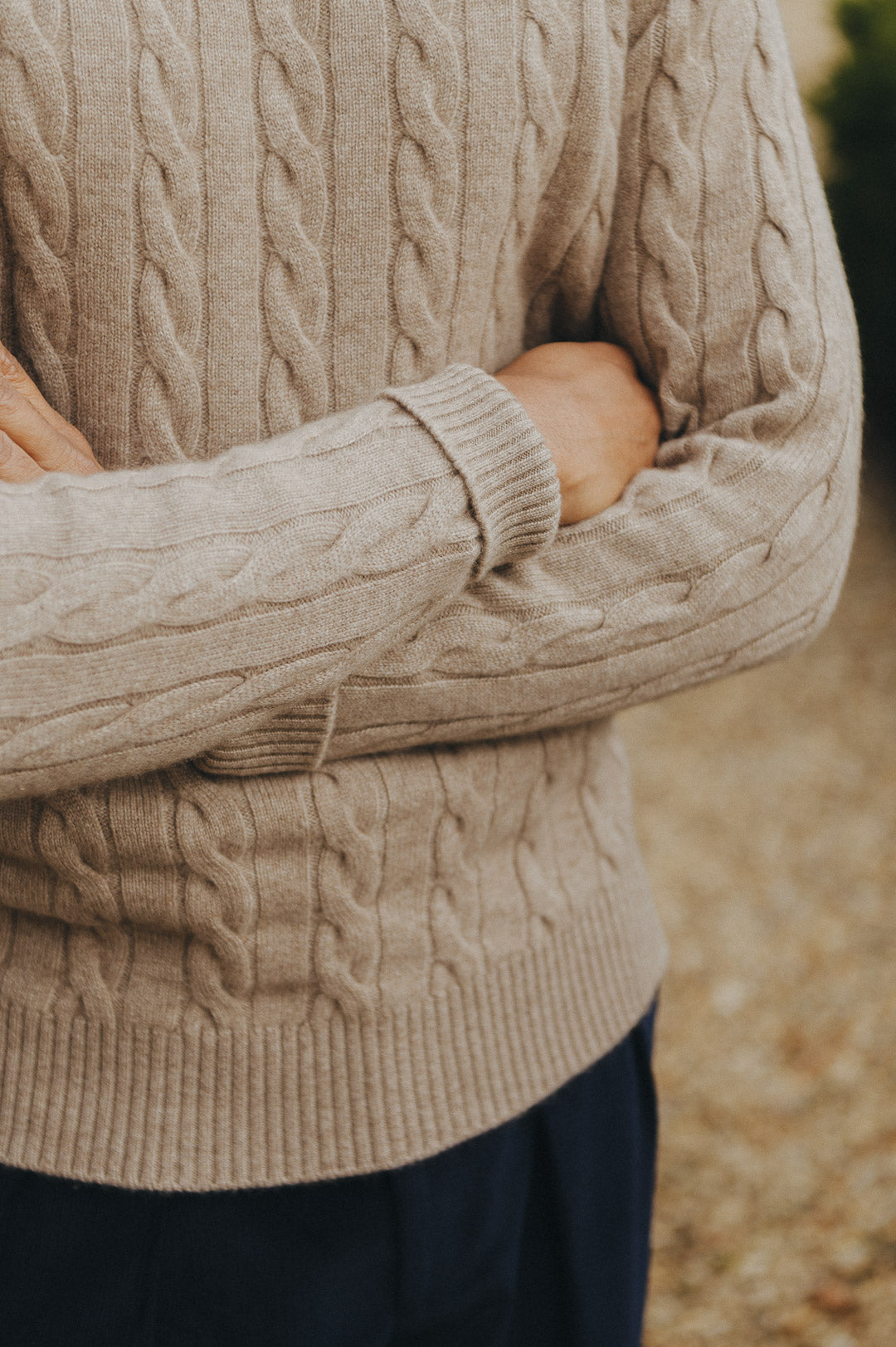 Close up of man wearing cashmere jumper in beige with arms crossed