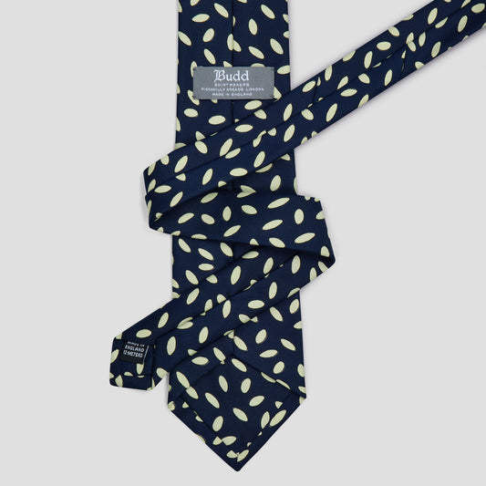 Hand-made navy silk tie featuring an ivory seed motif pattern and an 8.5cm blade, crafted in England.