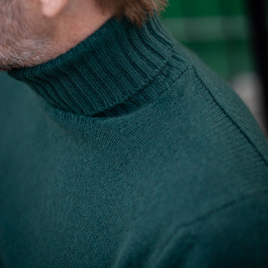 Collar detail of Cashmere roll neck jumper in Bottle green