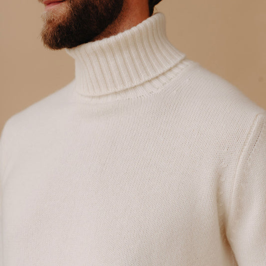 Closeup of  collar detail of model wearing  cashmere Roll Neck Jumper in Undyed White