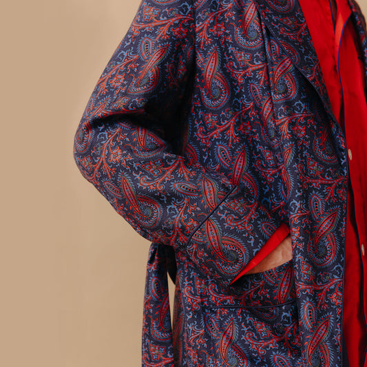 Close up of male model wearing Ornate Paisley Madder Silk Dressing Gown in Navy with red pyjamas