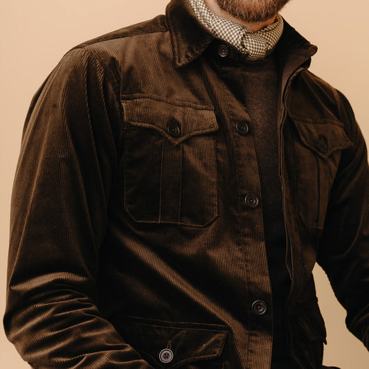 Male model close up image of chest pocket wearing Cotton Corduroy Safari Jacket in Olive on a plain cream background