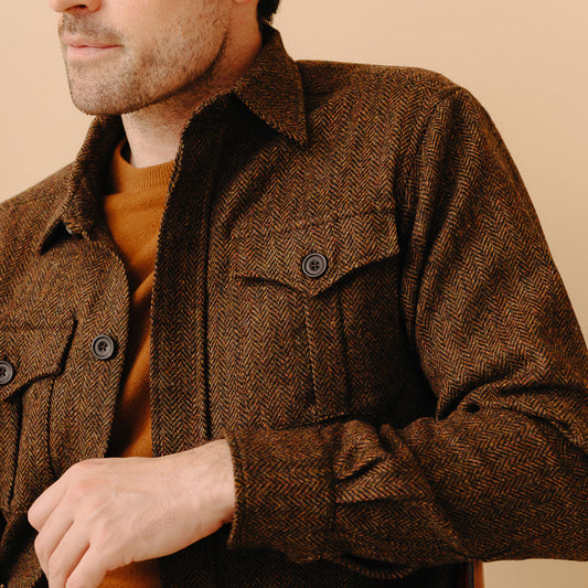 Male model wearing Herringbone Tweed Safari Jacket in Ashdown on plain cream background close up detail image of chest pocket