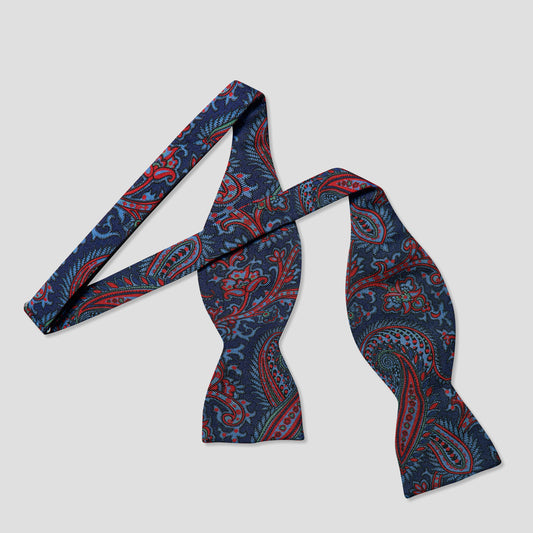 Patterned paisley madder silk bow tie on a pale grey background
