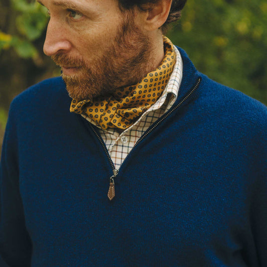 Man wearing a blue jacket with a patterned scarf outdoors