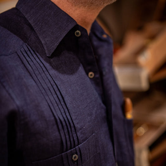 Close-up of a person wearing a dark blue shirt with a blurred background