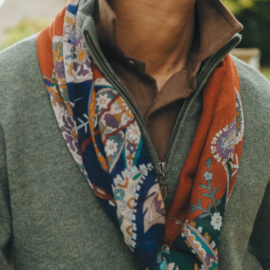Person wearing a colorful patterned scarf with a blurred background