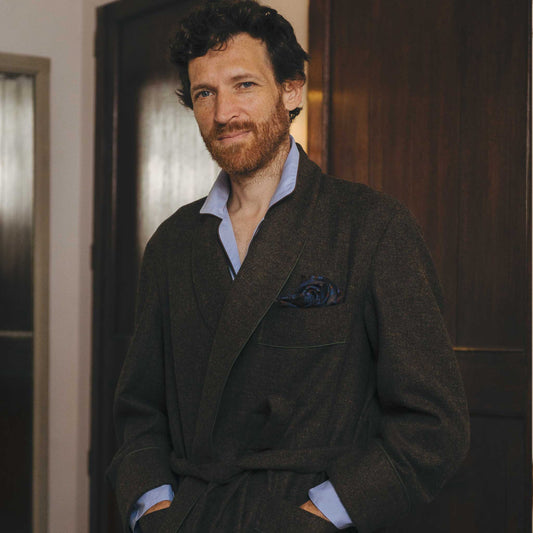 Male model wearing brown dressing gown stood in bedroom