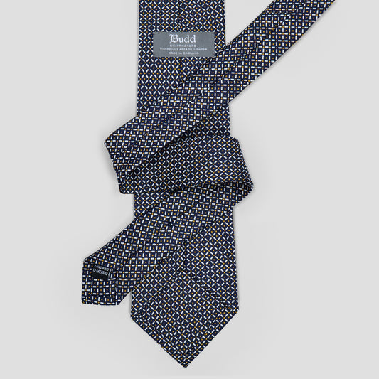 Navy silk tie featuring a geometric trellis and dot pattern, hand-made in England with an 8.5cm blade.