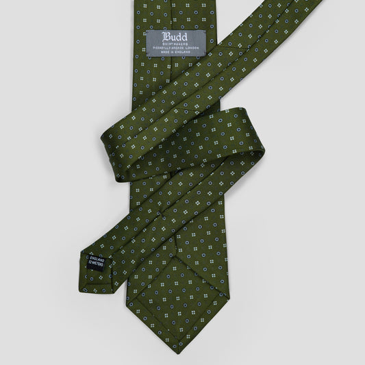 Olive green silk tie featuring navy and pale blue geometric dot medallions, hand-made in England with an 8.5cm blade.