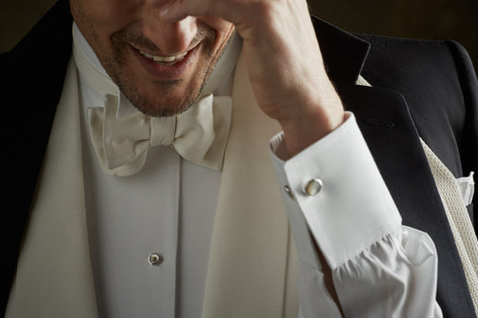 White Tie Tip close up image of man wearing white double cuff dress shirt, white bow tie and cufflinks