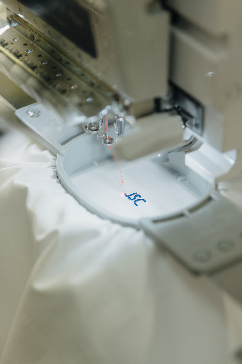 Close-up of a sewing machine needle and presser foot on fabric