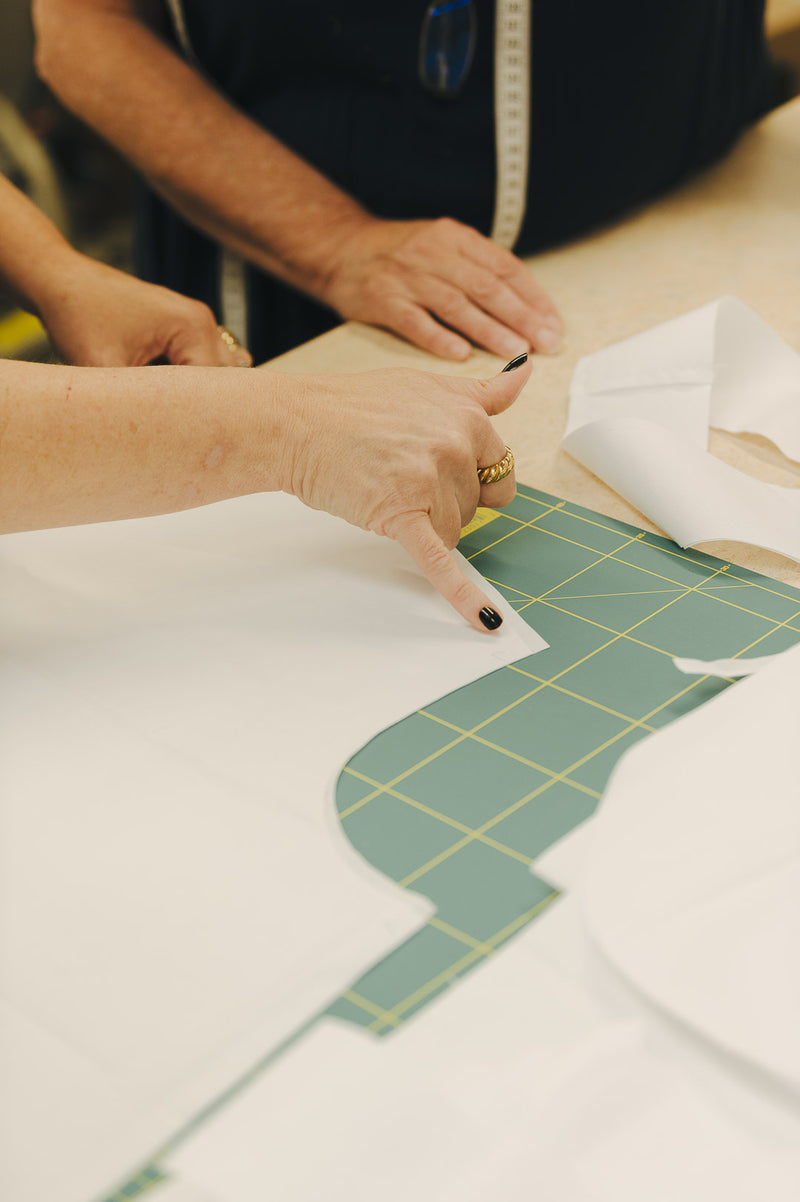 Shirt pattern with fabric laid out and female pointing to it