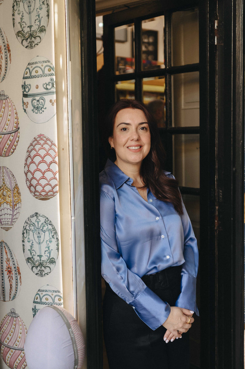 Shirt cutter stood in doorway of shirtmakers entrance