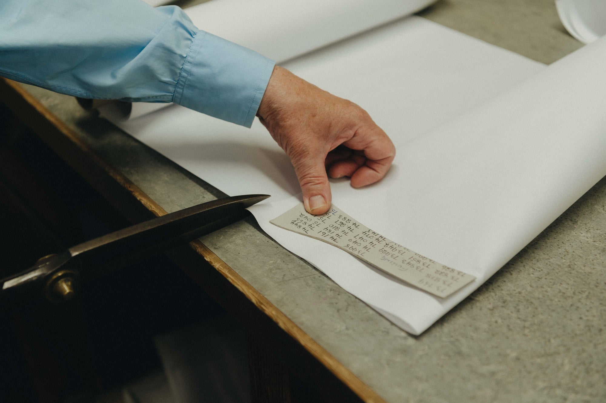 Shirt cutter cutting a white cloth fabric