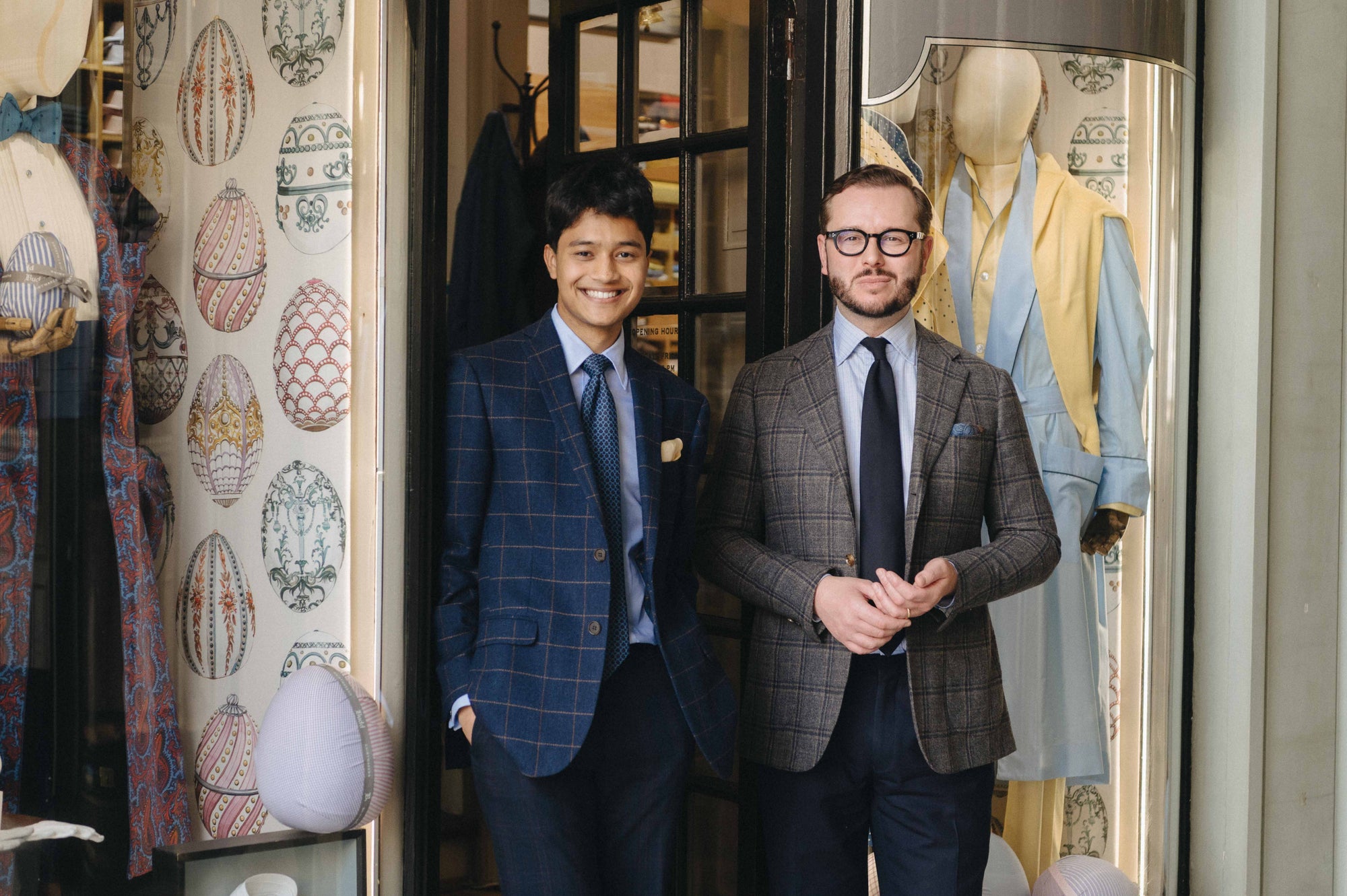 Two men stood outside menswear store front window in London