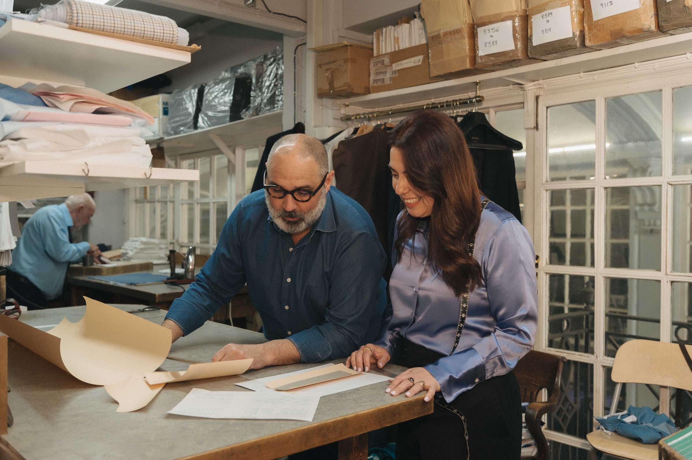 Two people working together at a table in a workshop setting.