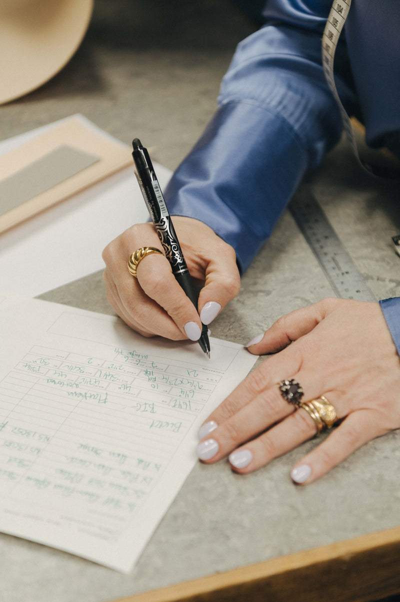 Ladies hand writing down shirt measurements
