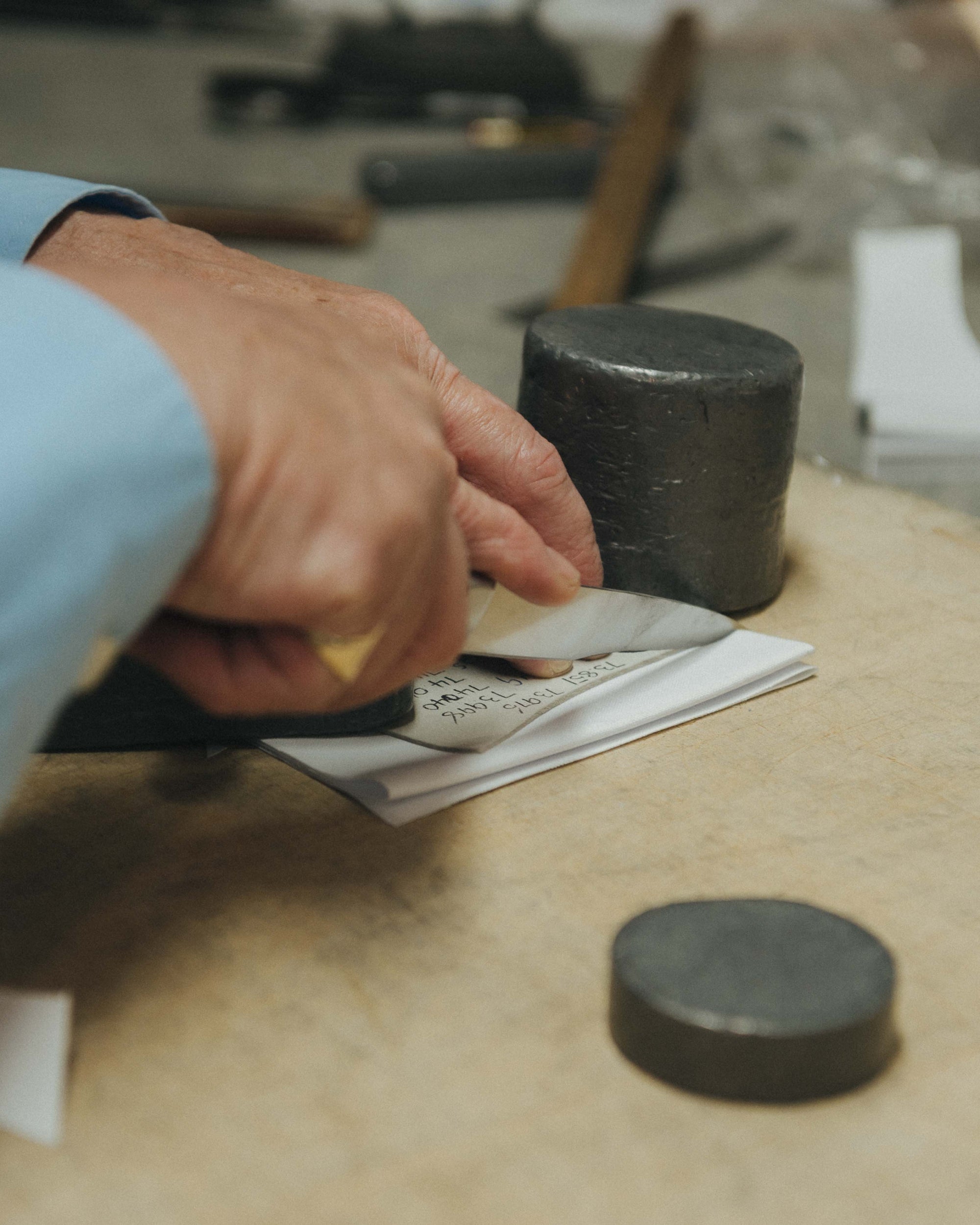 Person working with black cylindrical objects on a wooden surface