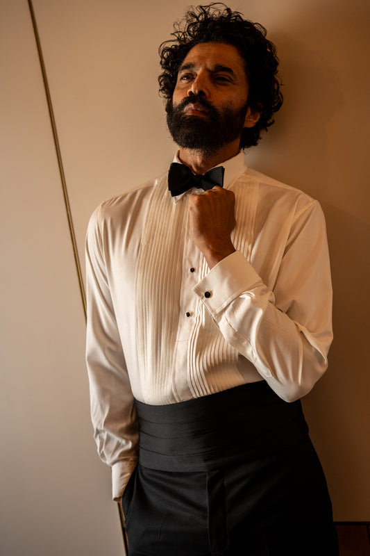 Model wears Cream spun silk Kirby Allison x Budd  1/4 hand-pleat evening dress shirt with black silk cummerbund and black bow tie