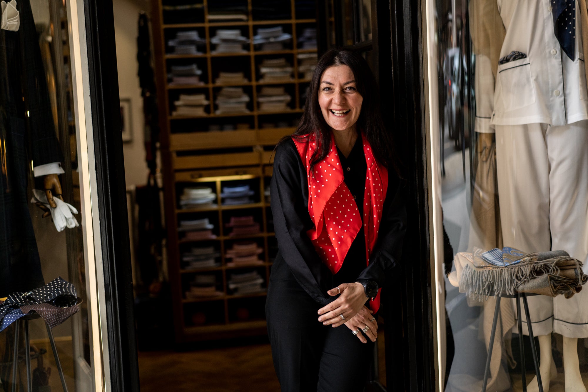 Woman wearing a red polka dot scarf in a clothing store