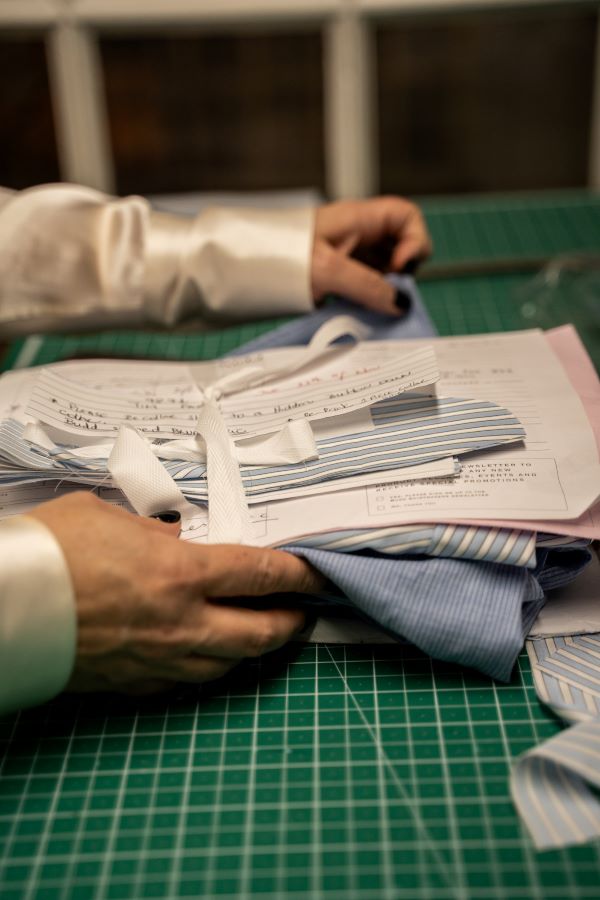 Person working with fabric and paper on a green cutting mat