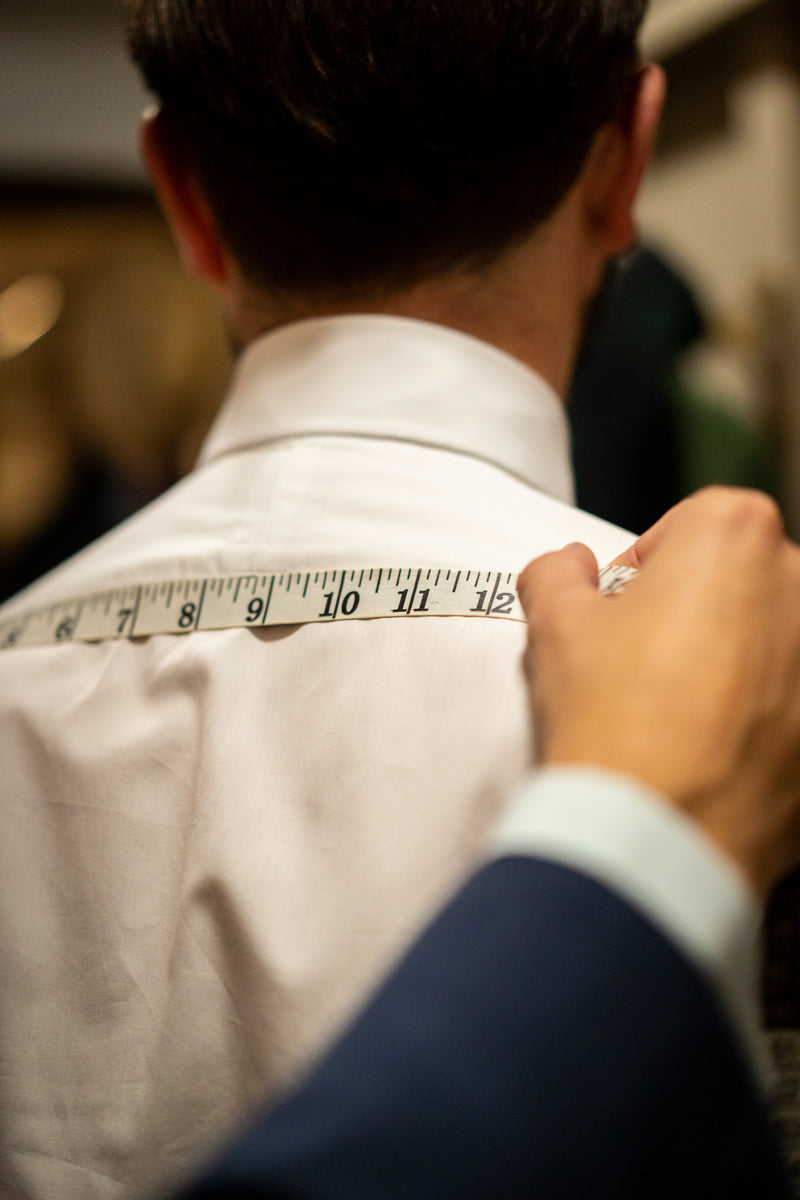 Man in white shirt being measured for back shoulder measurements