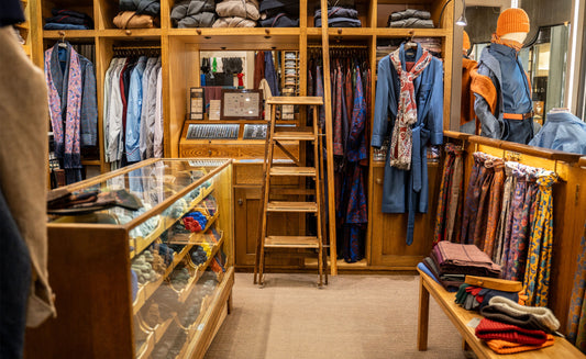 Budd Shirtmakers interior view of Piccadilly shop showing traditional shop counter, men's dressing gowns and scarves