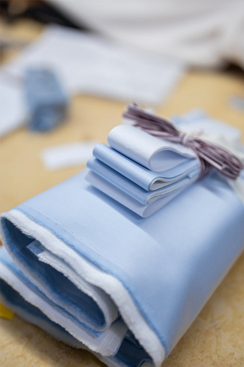 Stack of blue cloths ready for cutting at a workroom shirtmakers