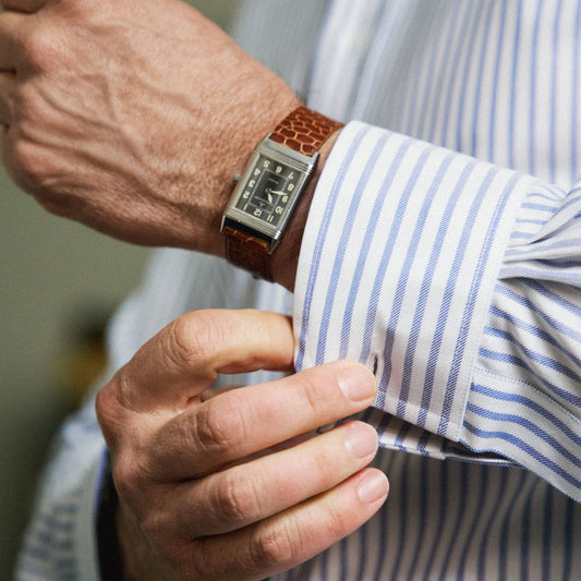 Close up of blue stripe button cuff shirt with man wearing watch