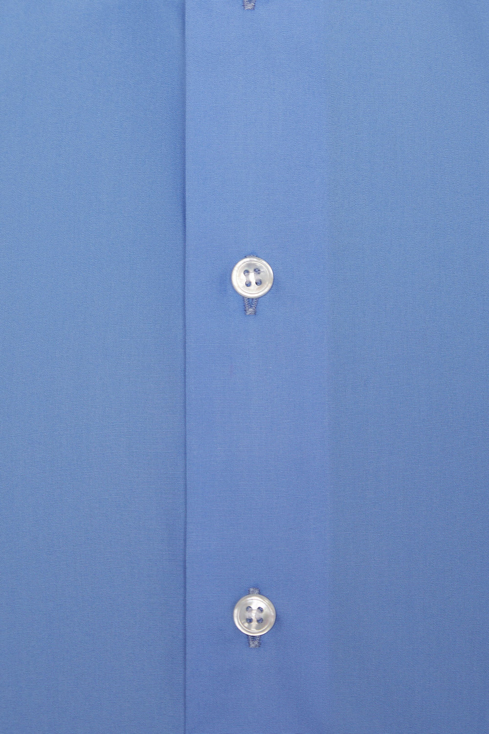 Close-up of a blue shirt with buttons on a matching fabric background