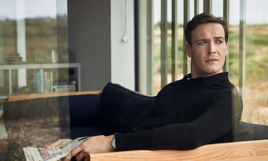 Man wearing merino wool knitted polo in black looking out the window