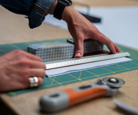 Shirt cutter measuring out shirt block pattern in shirtmaking workroom