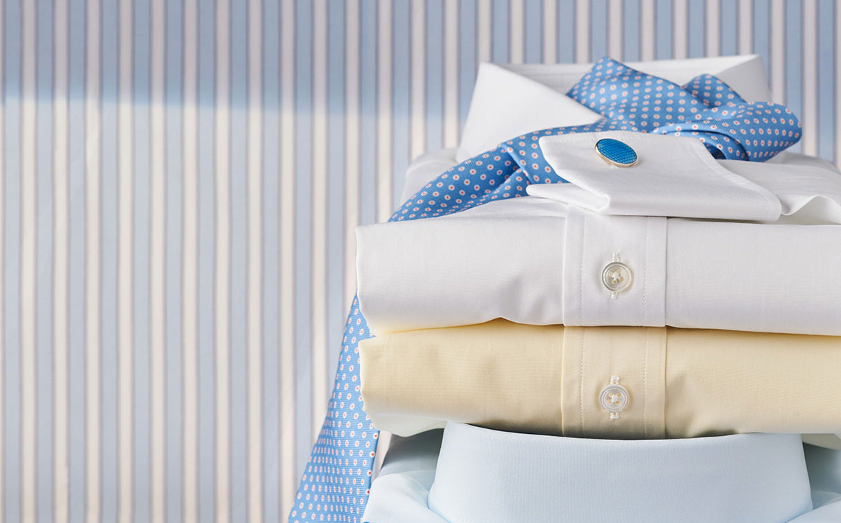 Stack of folded shirts on a striped surface