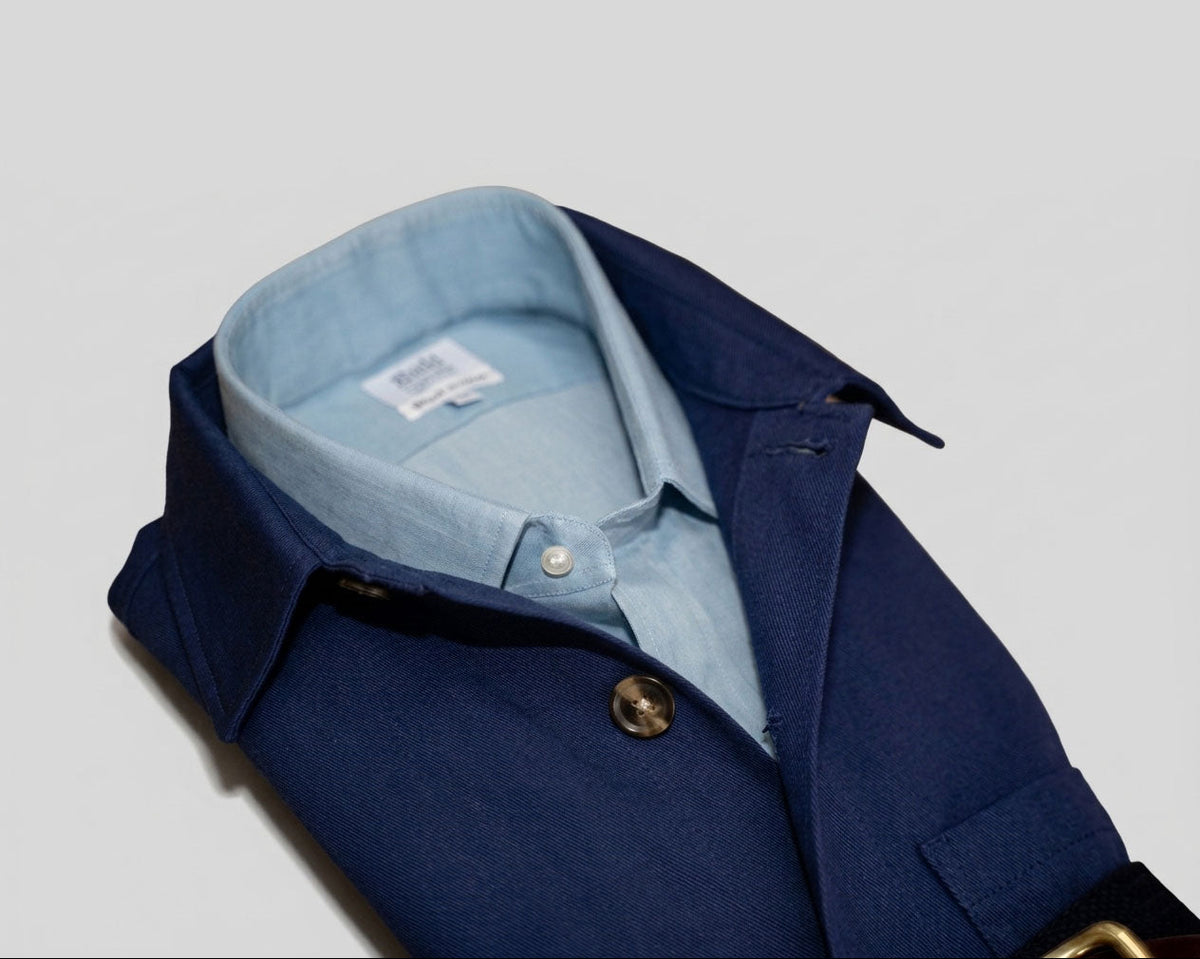 Blue coat with light blue shirt and visible brand label on a light gray background