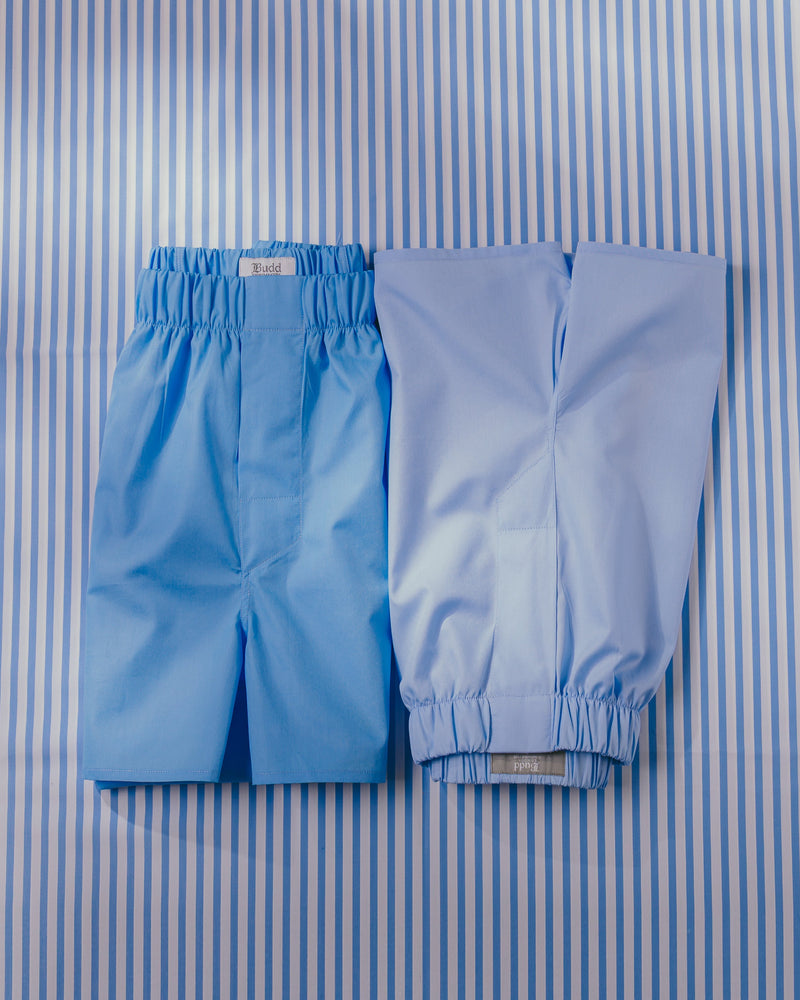 Two pairs of blue boxer shorts on blue stripe background