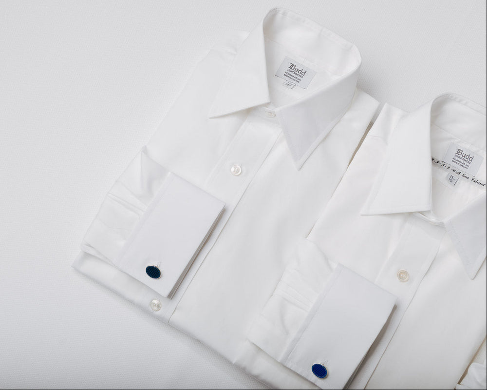 Two white shirts folded flat on a white background