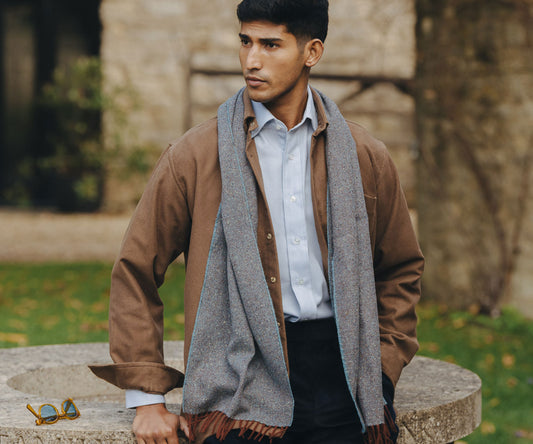 Man sat outside wearing grey scarf in Autumn scene
