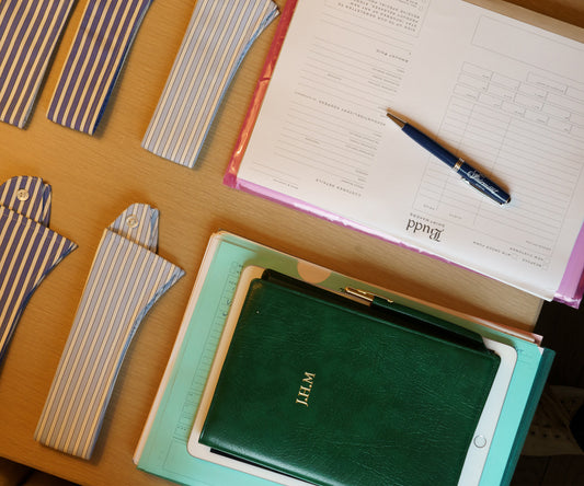 Flat shot from above of diaries and appointment forms with shirt collars for a Trunk Show 
